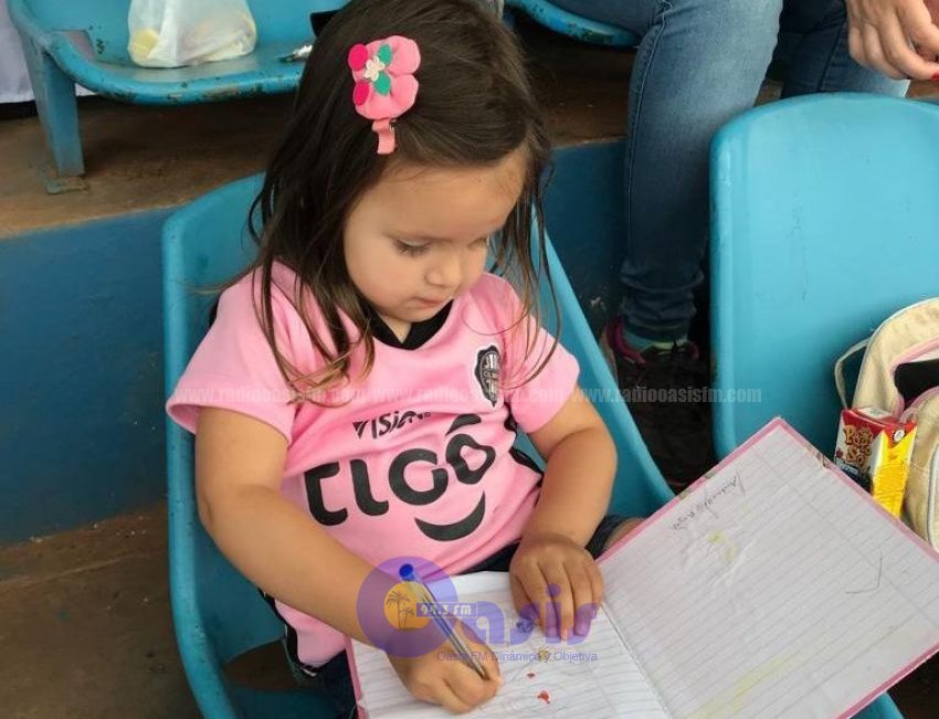 La pequeña hincha  Pedrojuanina que hace su tarea y alienta a Olimpia